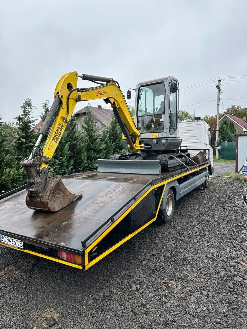 Жовтий мініекскаватор Wacker Neuson на евакуаторі у Львівській області